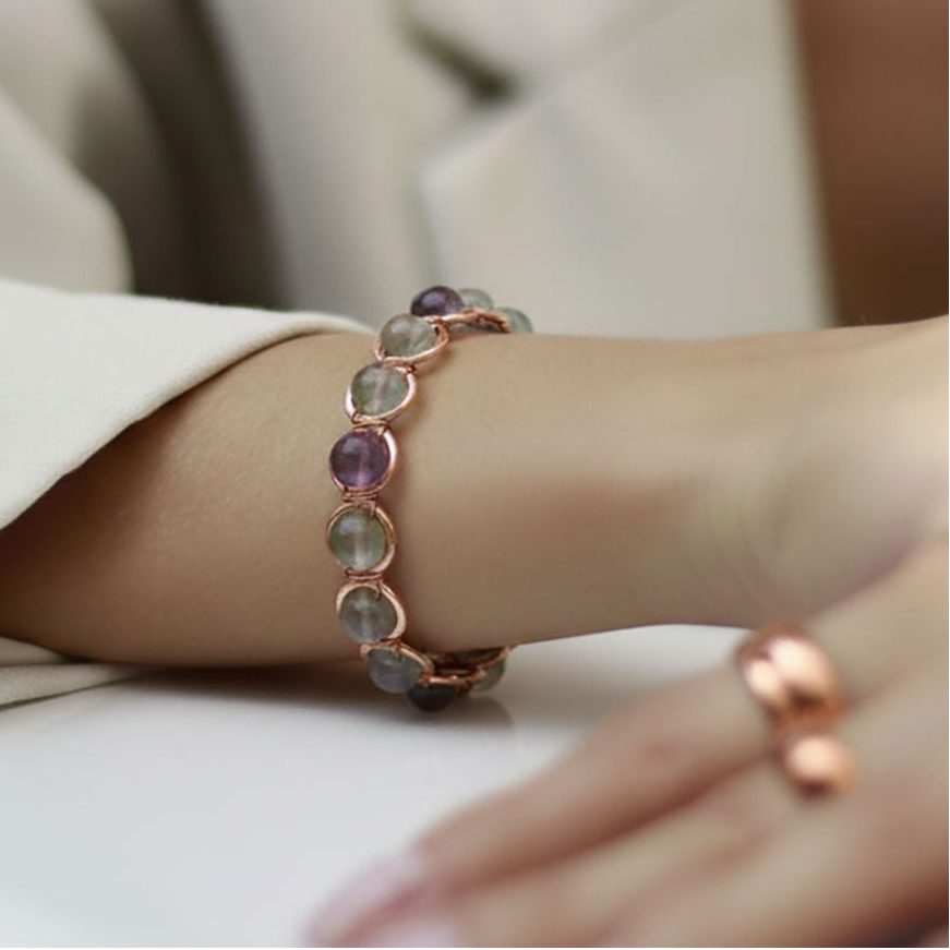 closeup van vrouwen hand met koperen armband met edelstenen